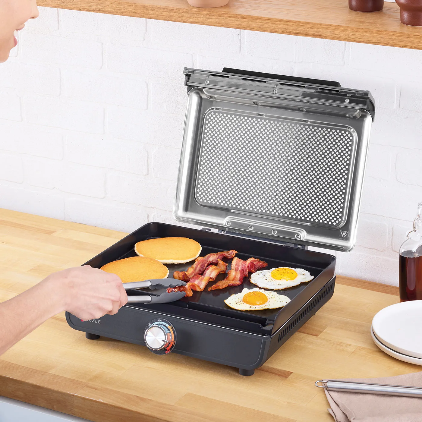 Ninja-GR101UK-InUse-Kitchen-Counter-Griddle-Pancakes-FriedEggs-Bacon-Woman-RGB